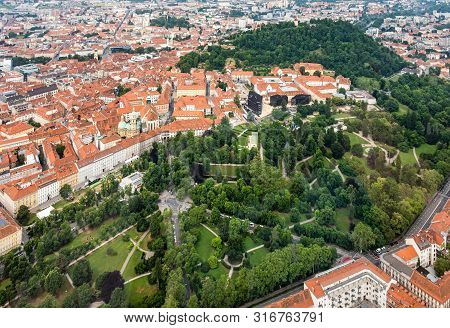 Aerial View Of Center City Graz From Helicopter Drone With Hill Schloßberg, Tower Uhrturm And Centra