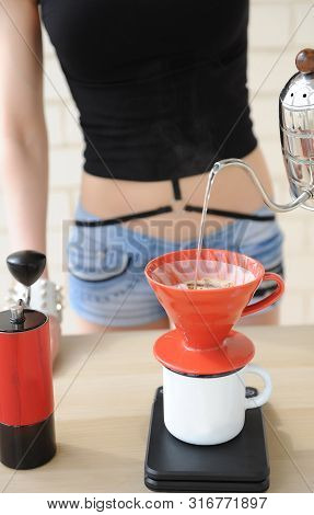 Girl Barista Brews Coffee Drip Method. Pouring Water From Gooseneck Kettle Into Red Hario V60 Funnel