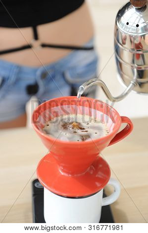 Girl Barista Brews Coffee Drip Method. Pouring Water From Gooseneck Kettle Into Red Hario V60 Funnel