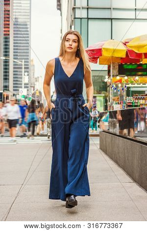 Young Eastern European Woman With Long Brawn Hair Traveling In New York City, Wearing Blue Sleeveles