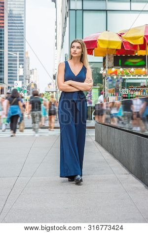 Young Eastern European Woman Traveling In New York, Wearing Blue Sleeveless Jumpsuit, Black Leather 