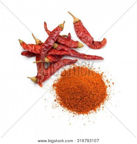 Heap of dried red chili peppers and a heap of chili powder isolated on white background