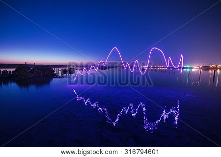 Amazing Laser Fireshow Performance In The Night Blue Sky With Reflections In The Sea Water