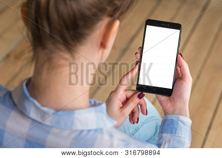 Mockup Image: Woman Looking At Black Smartphone With White Blank Screen. Close Up View Of Woman Hand