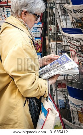 Strasbourg, France - May 25, 2019: Woman Reading German Taz Newspaper At Press Kiosk Featuring 2019 