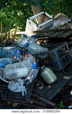 Inefficient waste from metal pipes, wooden boards, plastic bottles dumped in the forest