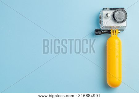 Action Camera In A Waterproof Box And A Buoy For Diving In Water Drops On A Blue Background. Copy Sp