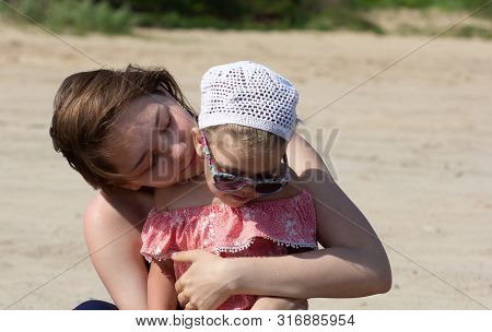 Young Woman Hugging A Child With Love And Tenderness