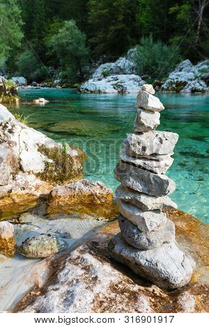 Zen-like Arranged Stack Of Stones At Beautiful Emerald Colored River Soca In Slovenia. Travel, Touri