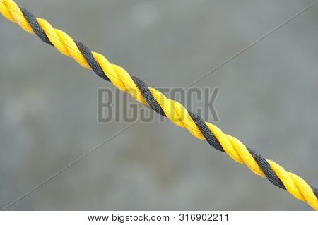 Yellow and Black Nylon Rope in Close-up. Nylon rope in diagonal direction. Isolated on blurred background. Copy space.
