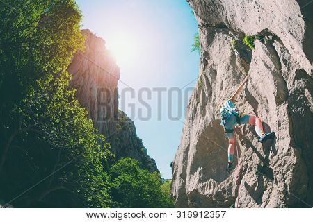 Rock Climbing And Mountaineering In The Paklenica National Park. A Woman Overcomes A Challenging Cli