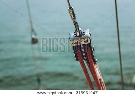 Close Up Of Yacht Equipment. Part Of Yacht With Red Ropes And Capstan. Sailing Boat Pulley With Naut