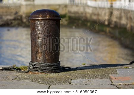 Photo Of A Metal Bolard With Rope, Selective Focus, Cold Colours And Sunlight.