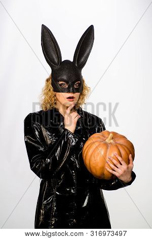 Thoughtful Young Girl In Black Halloween Costume. Serious Woman In Bunny Mask With Pumpkin. Sexy Gir