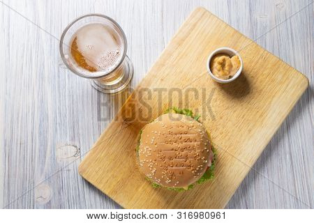 Burger With Beef Patty, Salad, A Slice Of Tomato And Cheese, Onions And Sauce With Paprika In A Gril