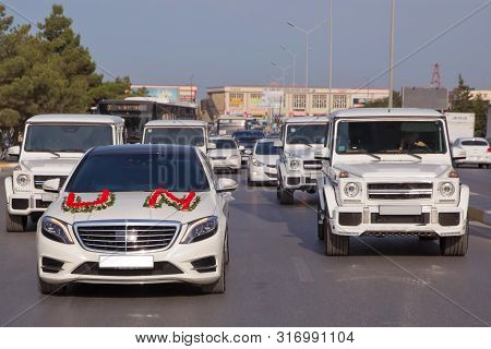Wedding Cortege In The Baku City Centre. Wedding Cortege At The Head Of The Car. Red And White Flowe