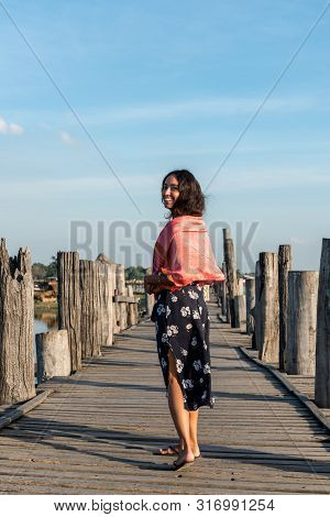 Vertical Picture Of Brunette Woman Smiling At Wooden U Bein Bridge, Which Is A Touristic Attraction 