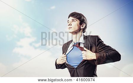 Image of young businessman showing superhero suit underneath his shirt