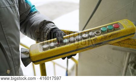 Male Hand Push Remote Control Switch For Overhead Crane In The Factory, Close-up. Electrical Control