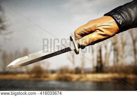 Detail Of Throwing Knife Holding In Hand Dressed In Leather Glove