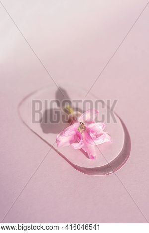A Drop Of Cosmetic Gel With Flower On A Pink Background.