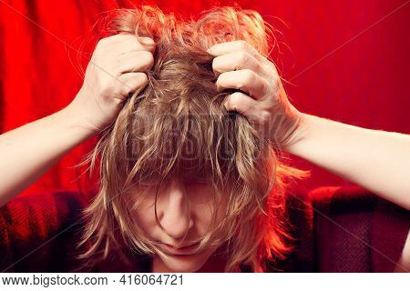 Portrait Of Tousled Disheveled Middle-aged Woman Looking Like A Madwoman On Red Background In Studio