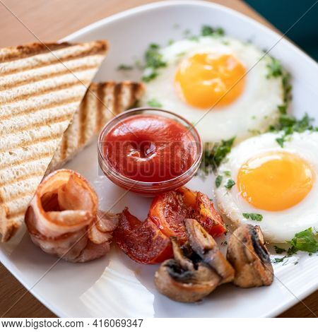 Traditional American Continental Breakfast. Fried Eggs With Bacon, Mushrooms And Toast. Plate Of Pro