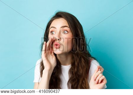 Cute Glamour Gossip Girl Spreading Rumours, Whispering News To Someone, Standing Voer Blue Backgroun