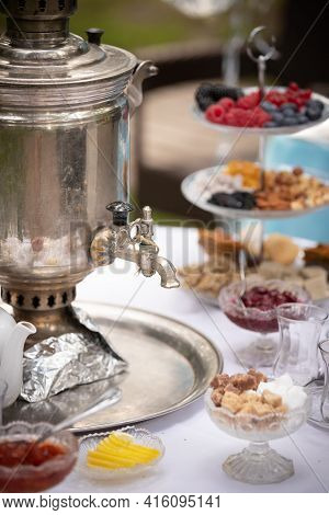 View Of A Round Table With Tea-ware From A Traditional Russian Samovar. Bakery, Sweet Food Concept. 