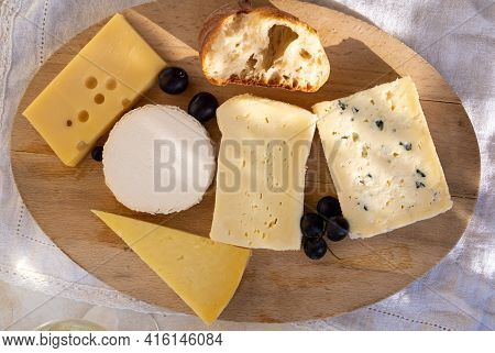 French Cheese Collection On Marble Board, Emmental, Carre De Aurillac, Petit Cantal Aop Jeune, Buche