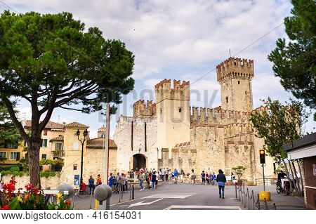 Sirmione, Italy-october 9, 2018: People Relax In The Town Of Sirmione Near The Castle Of Scaligera