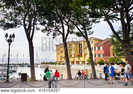 Sirmione, Italy-october 9, 2018: People Relax In The Town Of Sirmione Near The Castle Of Scaligera
