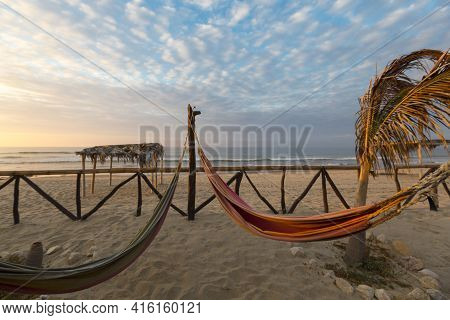 View Of Cozy Straw Hammocks On A Tropical White Beach With Sunset Light, Punta Sal Near Mancora In P