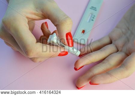 Coronavirus Test On A Pink Matte Background. Medical Procedure. Medical Analysis. A Girl With A Brig