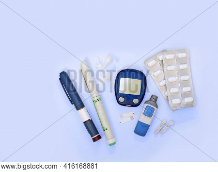Diabetic Kit: Glucometer, Test Strips, Lancet, Metformin Tablets. Top View, Blue Background, Empty S