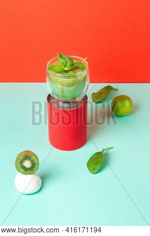 Concept Detox Cocktail With Kiwi, Mint And Lime In A Glass With Double Walls On A Red Stand. Red And