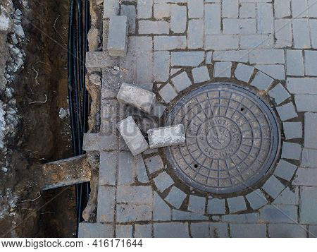 Cable Layout Into A Trench And Connection Into A Sewer Well, Sewerage Hatchway, Pavement Background