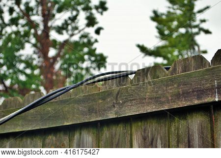 Dangerous Live Downed Power Line Draped Across Fence