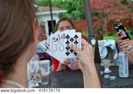 Over The Shoulder View Of A Young Woman Playing Cards