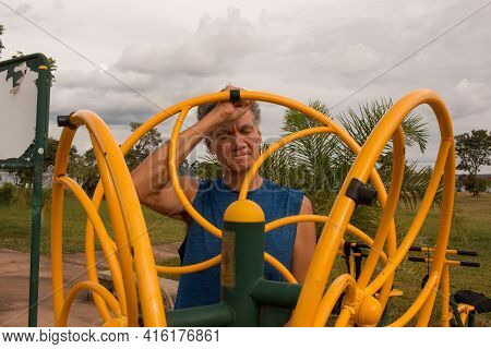 Senior Man Working Out At An Outdoor Fitness Park In Parque Das Garças, Brasilia