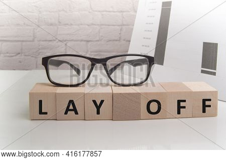 The Lay Off Text Is Written On Wooden Cubes That Contain Glasses, A Dismissal, An Office Space With 