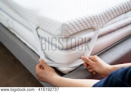 Mattress Topper Being Laid On Top Of The Bed