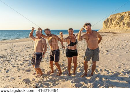 Group Of Mature Happy Active Adults Having Fun In The Beach. Long Time Friends
