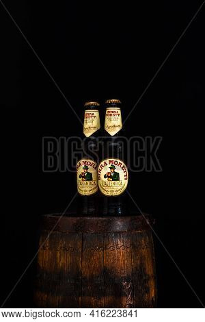 Bottle Of Birra Moretti Beer On Wooden Barrel With Dark Background. Illustrative Editorial Photo Buc