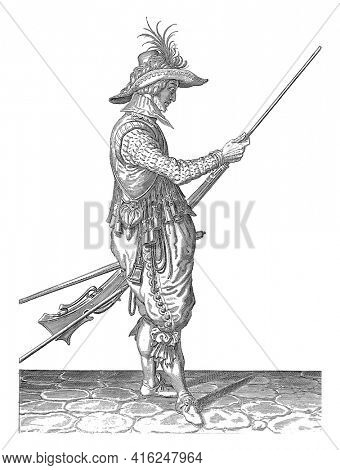 A soldier, to the right, holding a musket with his left thigh with his left thigh and using his right hand to bring in his ramrod to push gunpowder and bullet, vintage engraving.