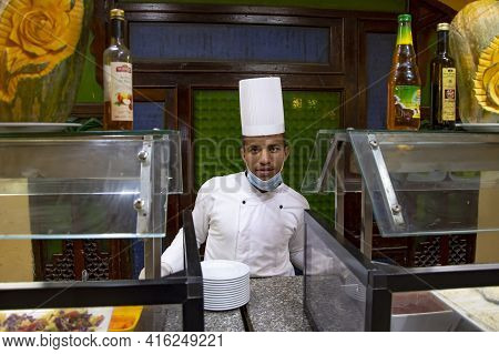 Portrait Of A Dark-skinned Male Chef At The Counter At The Food Distribution, Serving Staff In A Res