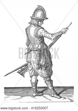 A Soldier, to the right, holding a rudder with his left thigh and moving his ramrod with his right hand to push gunpowder and bullet, vintage engraving.