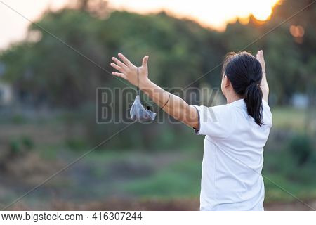 Asian Man Take Off Mask And Rise His Hand Up In Golden Twilight Time.