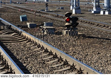 Railway Embankment With Rails And Glowing Red Light Semaphore Close-up Without Trademarks