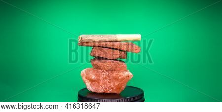 A Hand Rolled Marijuana Joint Balances On Top Of A Stack Of Red Sand Stone And Himlayan Pink Sea Sal